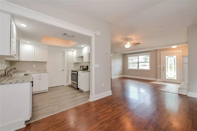 a view of a kitchen with a white kitchen stove a sink dishwasher and a refrigerator with wooden floor