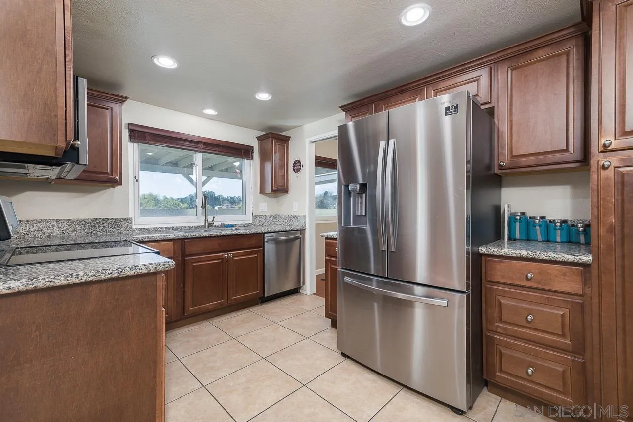 3061 Gayla Court Spring Valley, CA 91978 - Photo 8 of 31 a kitchen with granite countertop stainless steel appliances a refrigerator cabinets and wooden floor