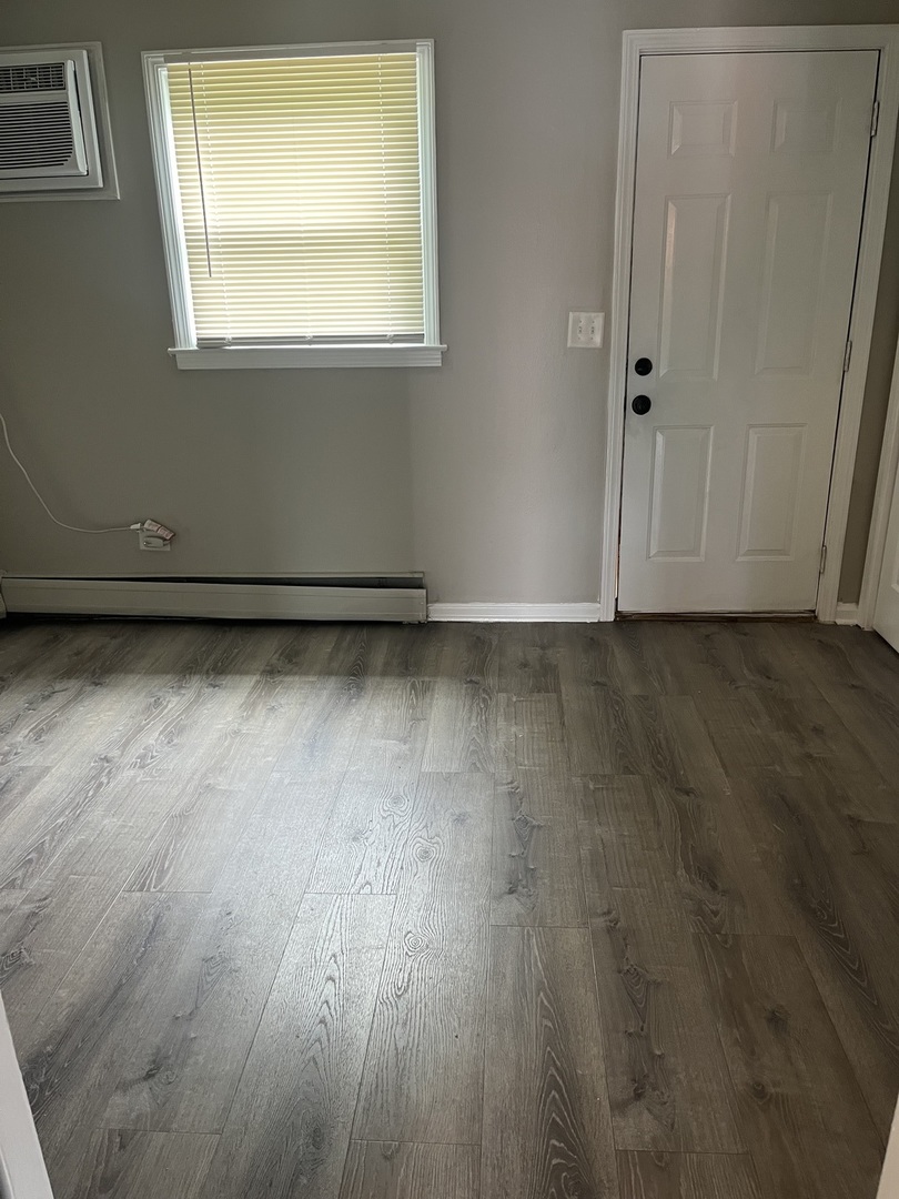 1340 North Main Street, Unit A7 Wheaton, IL 60187 - Photo 7 of 7 a view of an empty room with wooden floor and a window