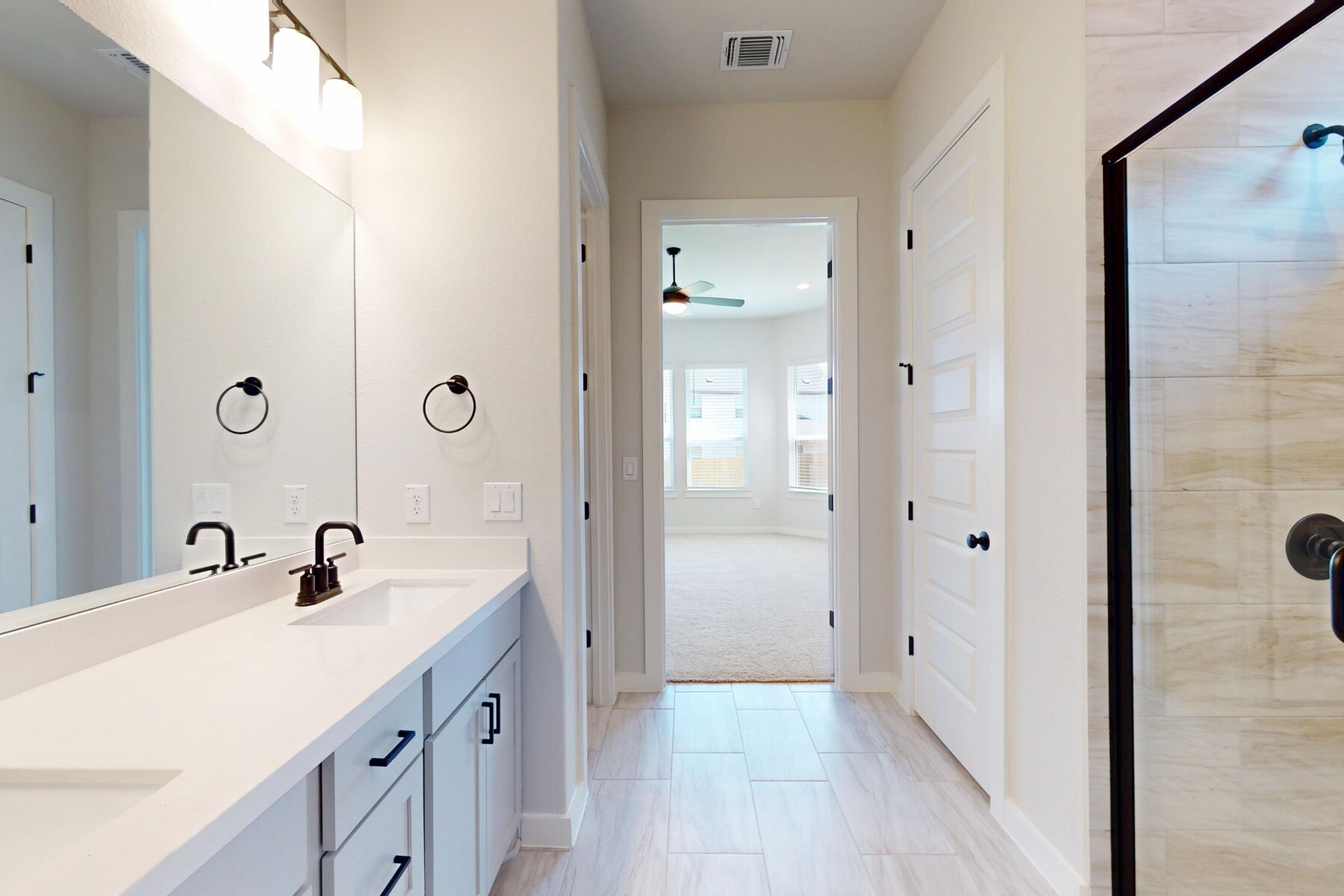 20117 Aqua Reef Drive Austin, TX 78747 - Photo 16 of 40 a bathroom with a double vanity sink a mirror and shower