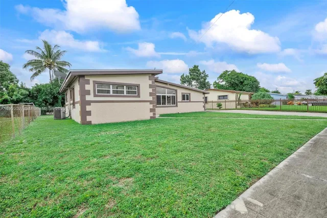 a view of a house with a yard and sitting area