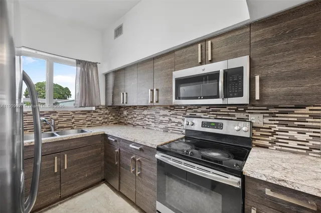 a kitchen with sink stove and microwave