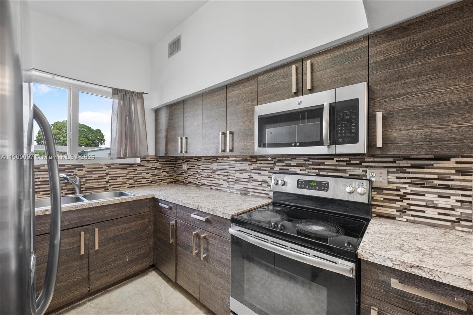 1960 Northwest 187th Street Miami Gardens, FL 33056 - Photo 7 of 23 a kitchen with sink stove and microwave