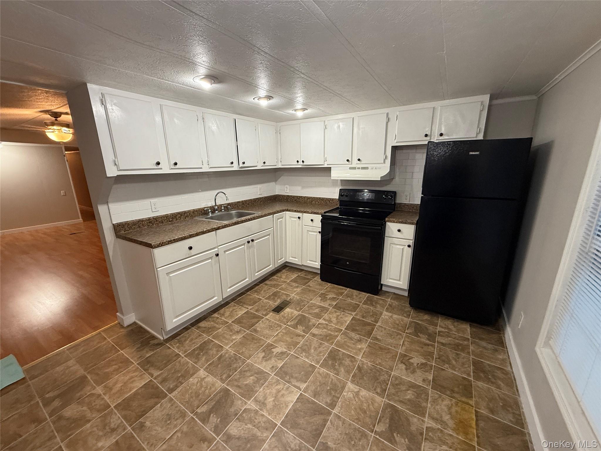 412 Cologne Avenue Wallkill, NY 12589 - Photo 3 of 16 a kitchen with granite countertop a refrigerator and a stove