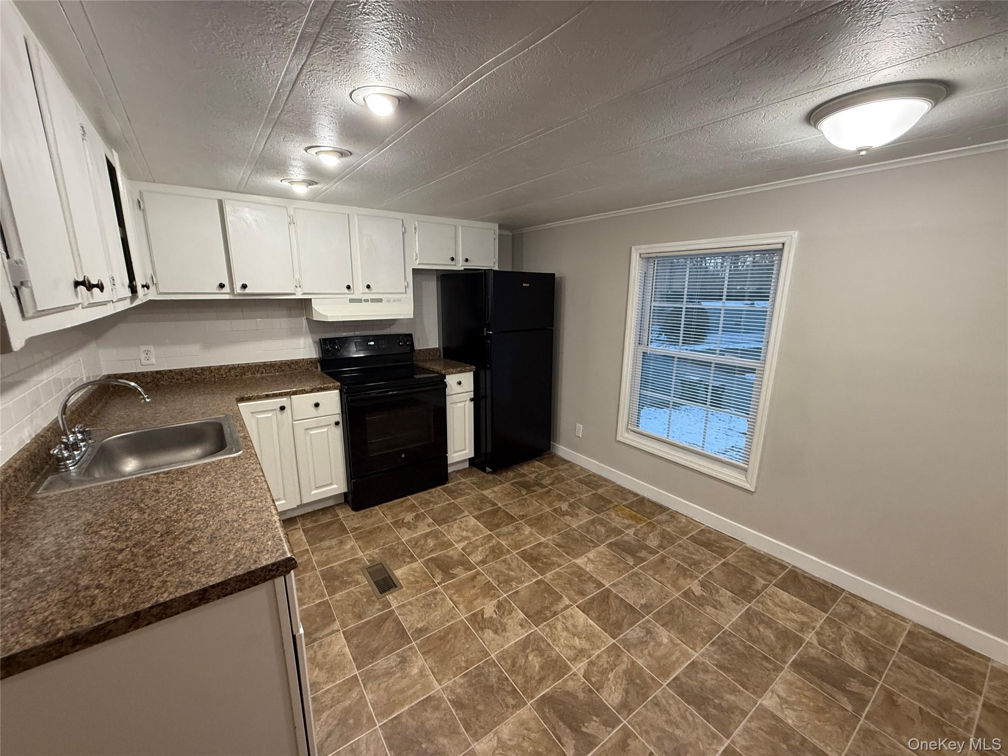 412 Cologne Avenue Wallkill, NY 12589 - Photo 4 of 16 a kitchen with stainless steel appliances granite countertop a sink stove and refrigerator