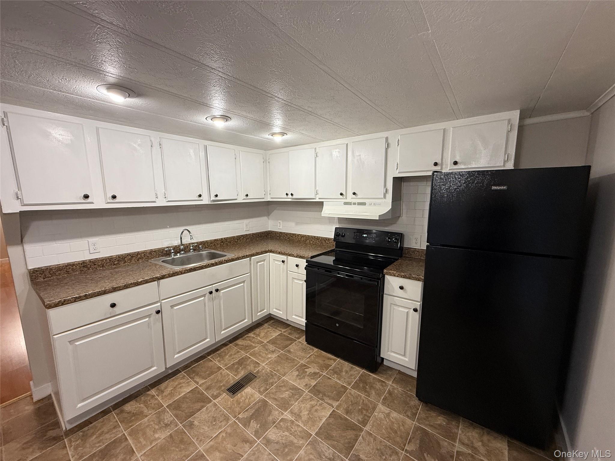 412 Cologne Avenue Wallkill, NY 12589 - Photo 5 of 16 a kitchen with granite countertop white cabinets and refrigerator