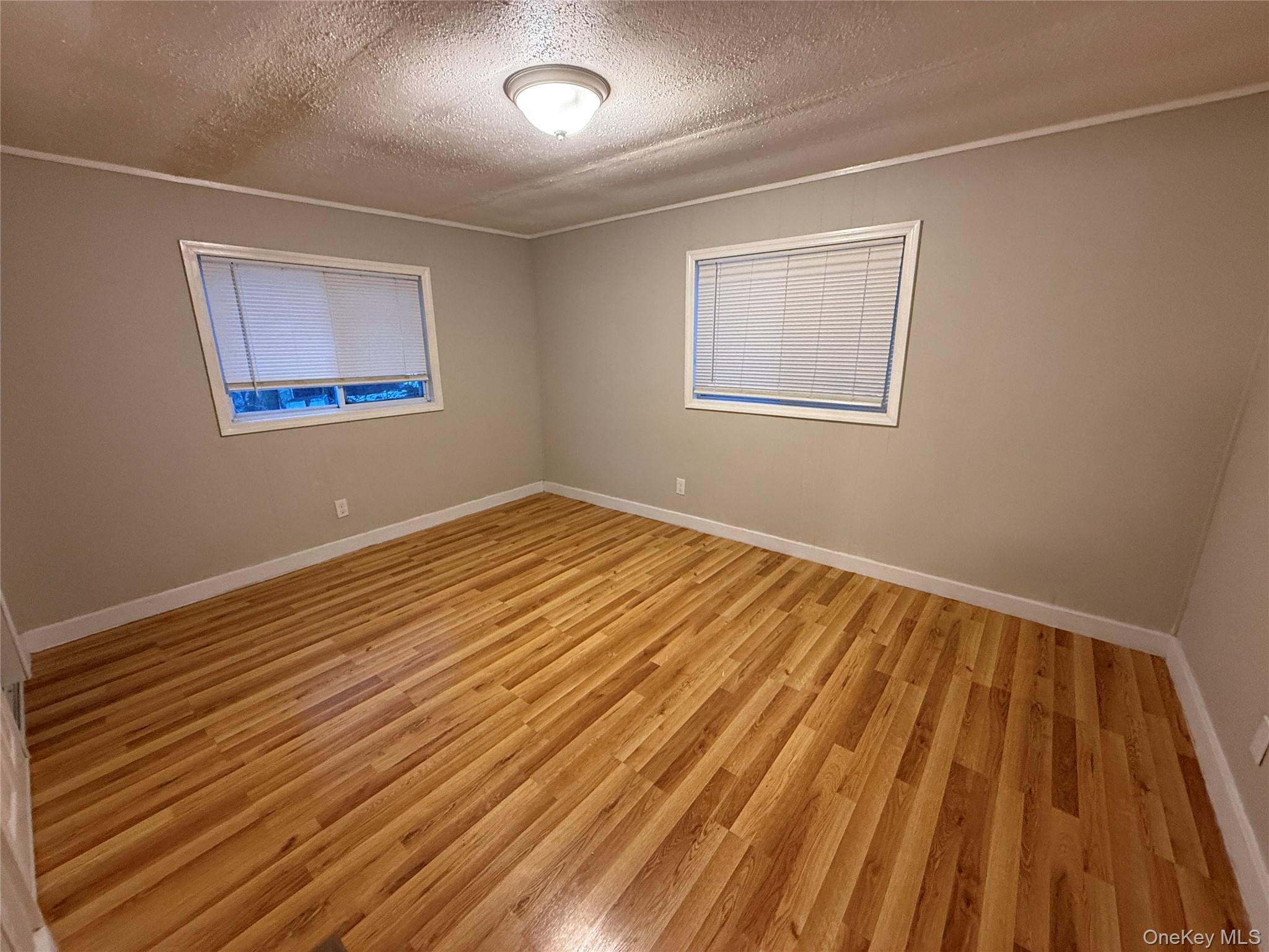 412 Cologne Avenue Wallkill, NY 12589 - Photo 10 of 16 a view of an empty room with wooden floor and a window