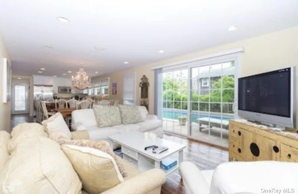 a living room with furniture flat screen tv and a large window