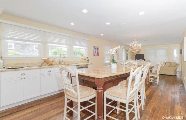 a kitchen with a dining table chairs and white cabinets