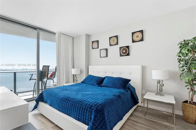 a bedroom with a large bed and paintings on the wall