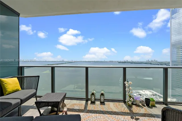 a balcony with dining table and chairs