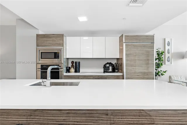 a view of kitchen with stainless steel appliances kitchen island sink and stove