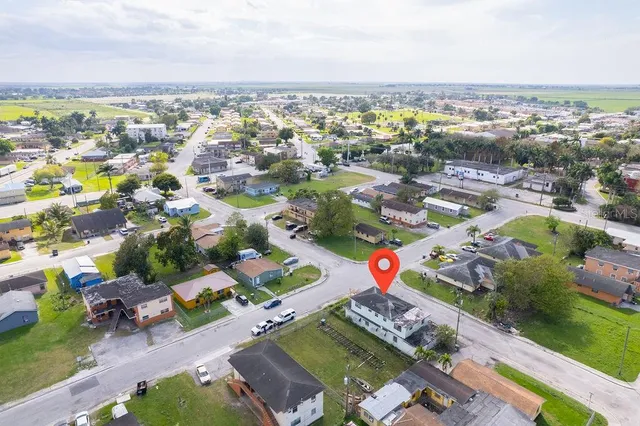 an aerial view of a city with lots of residential buildings ocean and mountain view in back