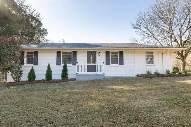 a view of a house with a patio and a yard