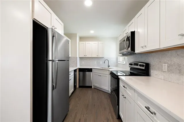 a kitchen with a refrigerator sink and cabinets