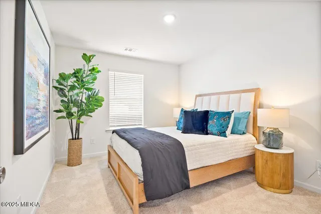 a bedroom with a bed and a painting on the wall