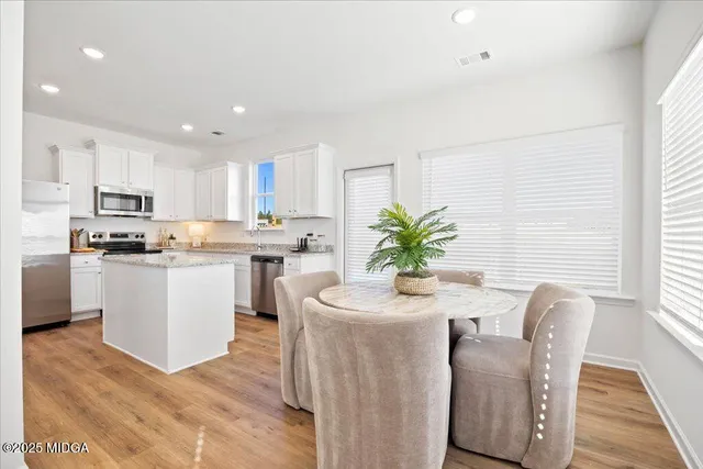 a kitchen with white cabinets and stainless steel appliances
