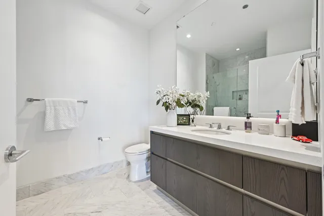 a bathroom with a double vanity sink toilet and a mirror