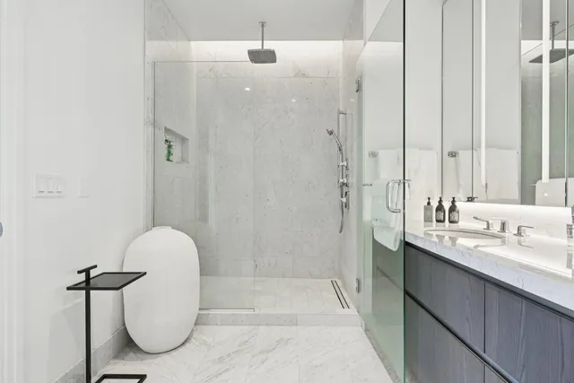 a bathroom with a granite countertop sink a toilet and shower