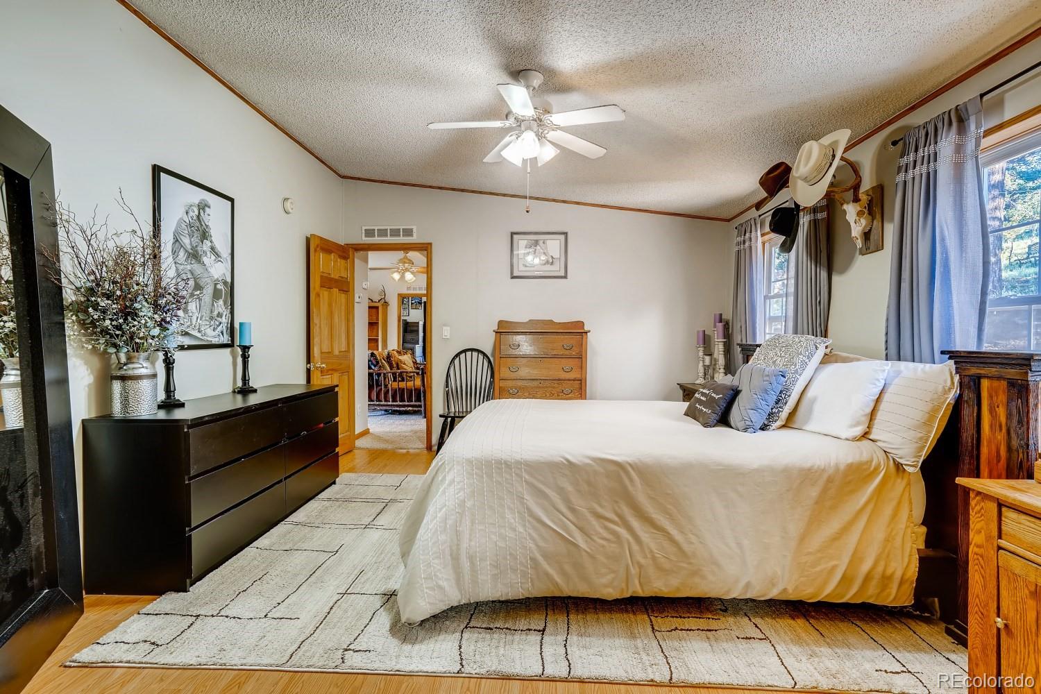 487 North Random Road Bailey, CO 80421 - Photo 18 of 28 a bedroom with a bed and a chandelier