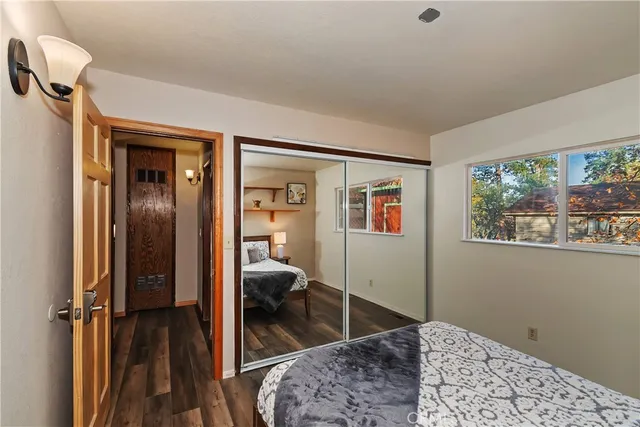 a bedroom with a bed a dresser and painting on the wall