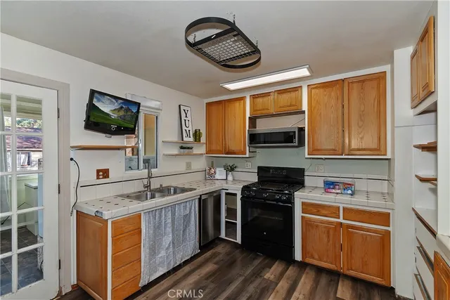 a kitchen with stainless steel appliances granite countertop a stove a sink and a microwave