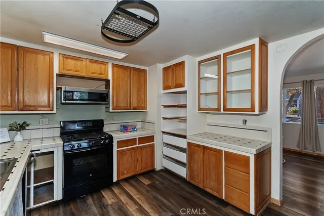 a kitchen with stainless steel appliances granite countertop a stove a sink and a microwave