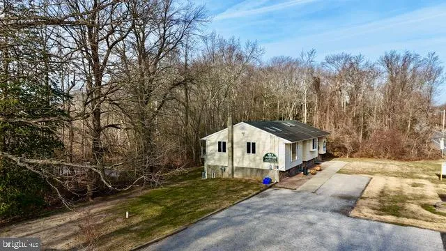 a white house covered with tall trees