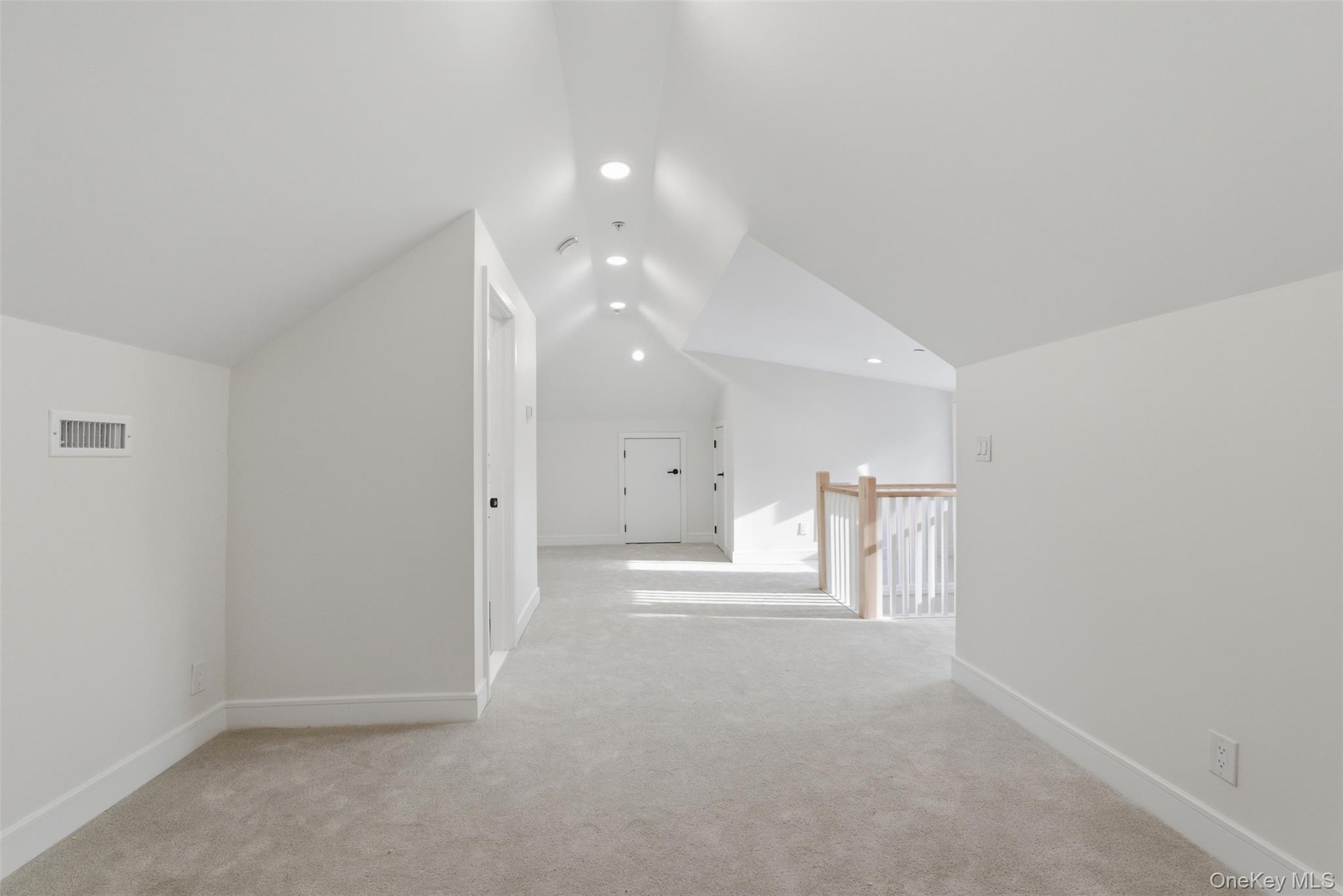 40 Calhoun Avenue New Rochelle, NY 10801 - Photo 28 of 49 Attic space featuring vaulted ceilings with recessed lighting, light-toned carpeting, and a wooden railing with white spindles