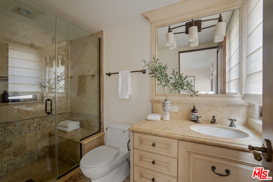6209 Ocean Front Walk Playa del Rey, CA 90293 - Photo 20 of 57 a bathroom with a granite countertop sink toilet a mirror a vanity and shower