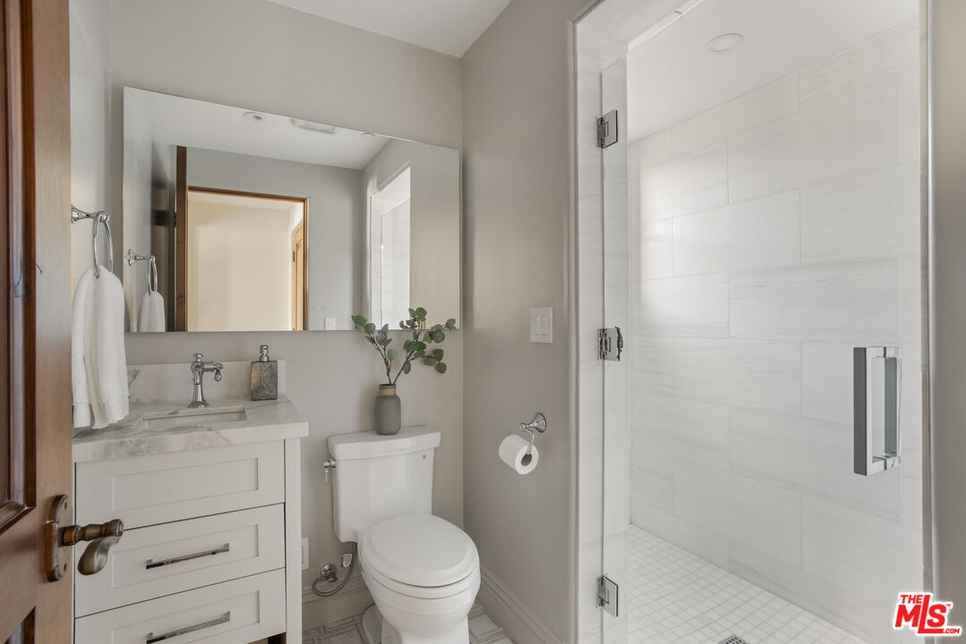6209 Ocean Front Walk Playa del Rey, CA 90293 - Photo 24 of 57 a bathroom with a toilet a sink a vanity and mirror