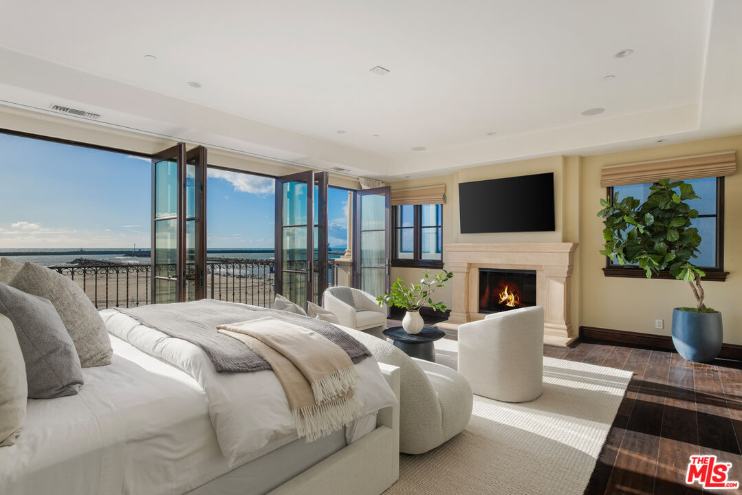 6209 Ocean Front Walk Playa del Rey, CA 90293 - Photo 29 of 57 a bedroom with a bed a flat screen tv and a fireplace