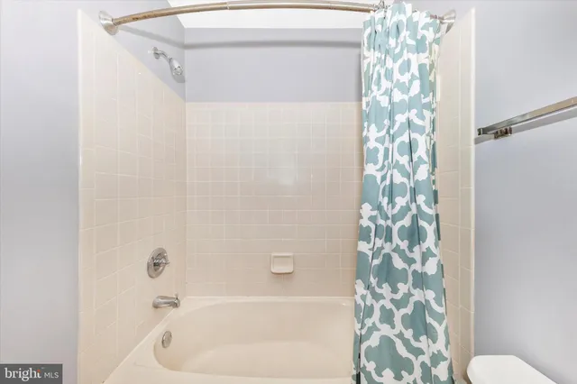 a bathroom with a shower curtain and a window
