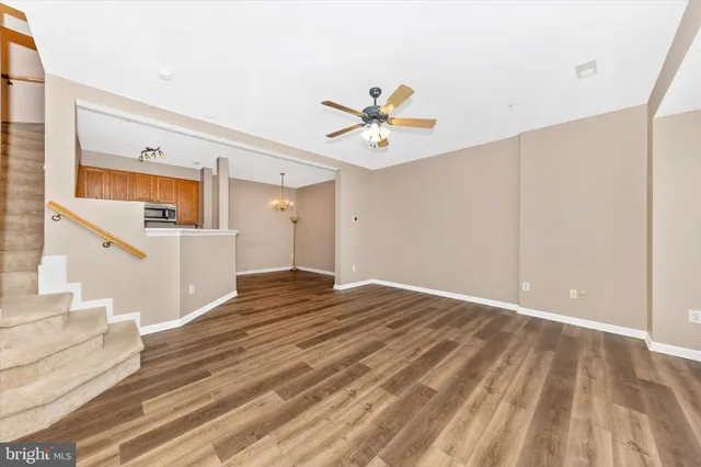 a view of a bedroom with wooden floor and a ceiling fan