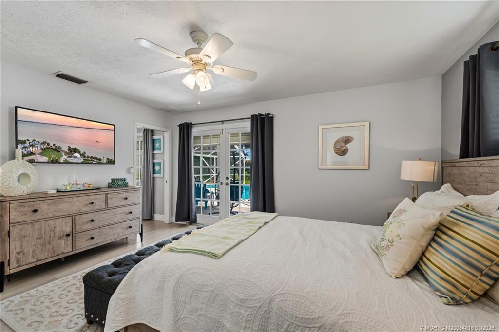 3160 Southeast Gran Via Way Stuart, FL 34996 - Photo 11 of 43 a bedroom with a bed and a chandelier
