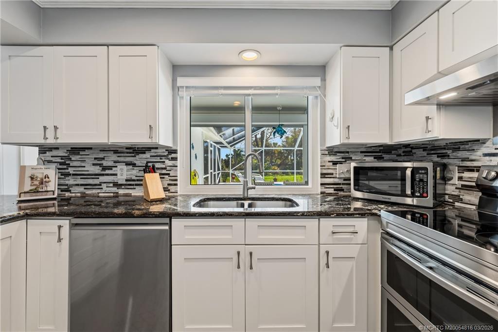 3160 Southeast Gran Via Way Stuart, FL 34996 - Photo 15 of 43 a kitchen with stainless steel appliances a sink stove and cabinets