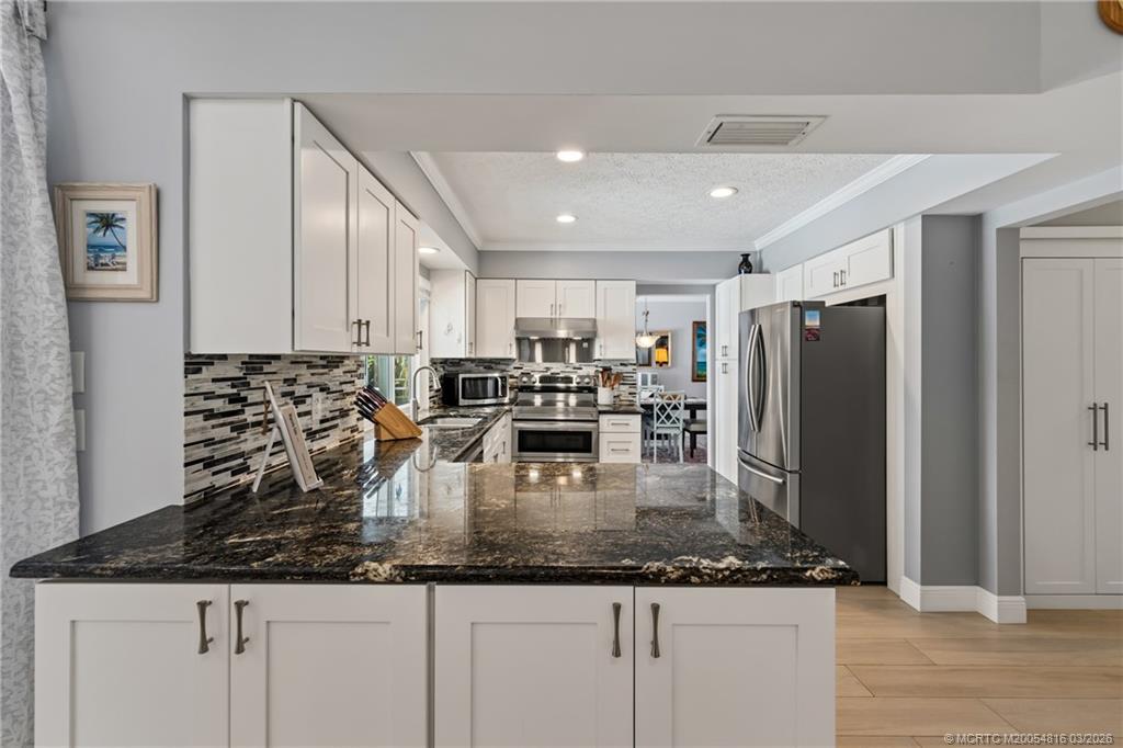 3160 Southeast Gran Via Way Stuart, FL 34996 - Photo 16 of 43 a kitchen with counter top space cabinets and stainless steel appliances