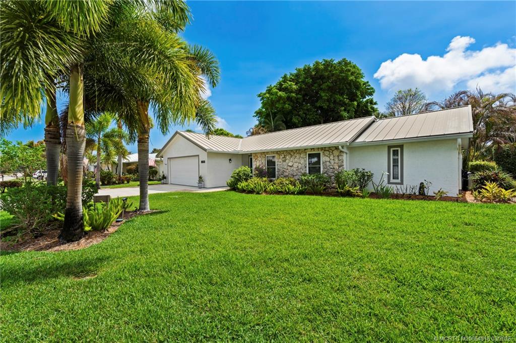 3160 Southeast Gran Via Way Stuart, FL 34996 - Photo 2 of 43 a view of a house with a yard and potted plants