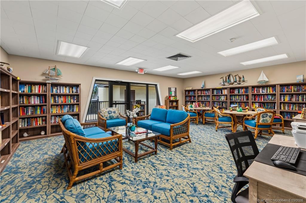 3160 Southeast Gran Via Way Stuart, FL 34996 - Photo 39 of 43 a living room with furniture a rug and a book shelf