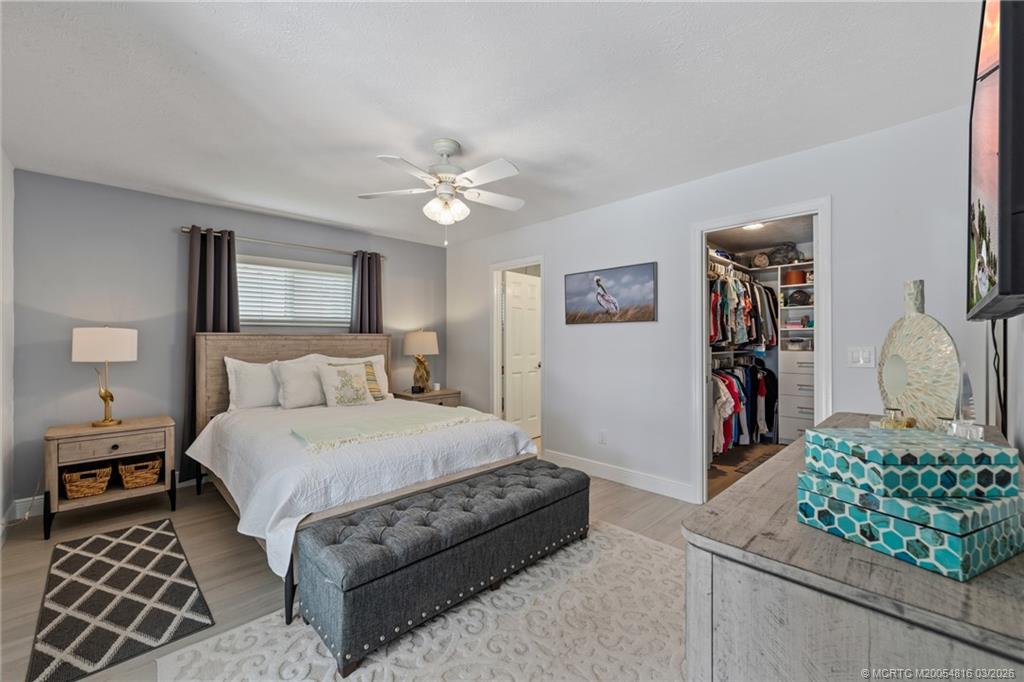 3160 Southeast Gran Via Way Stuart, FL 34996 - Photo 10 of 43 a large bedroom with a bed dresser and a window