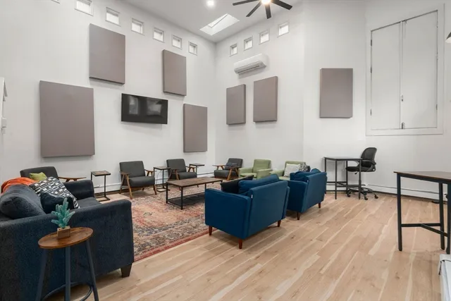 a living room with furniture a flat screen tv and kitchen view