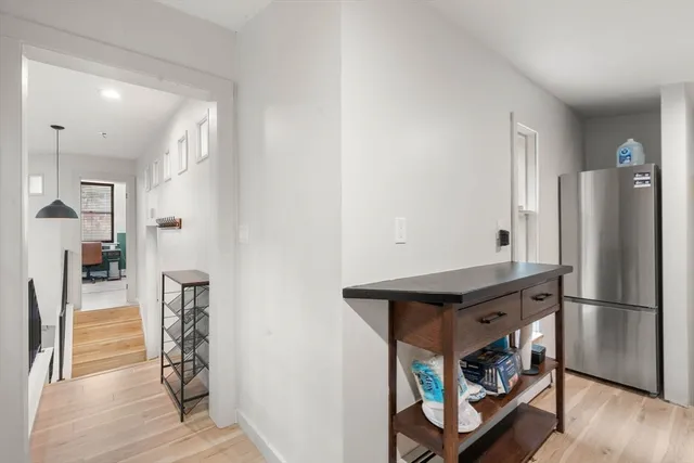 a kitchen with stainless steel appliances a refrigerator and wooden floor