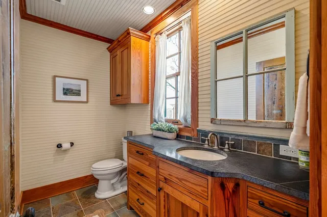 a bathroom with a granite countertop sink a mirror and a vanity
