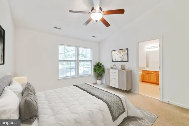 a bedroom with a large bed and a chandelier fan