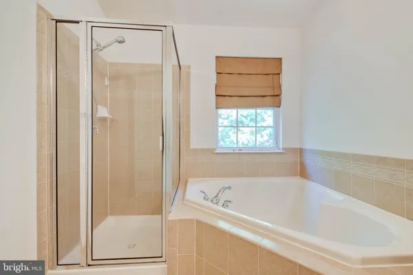 a bathroom with a granite countertop sink mirror and bathtub