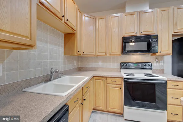 a kitchen with a white table chairs stove and cabinets