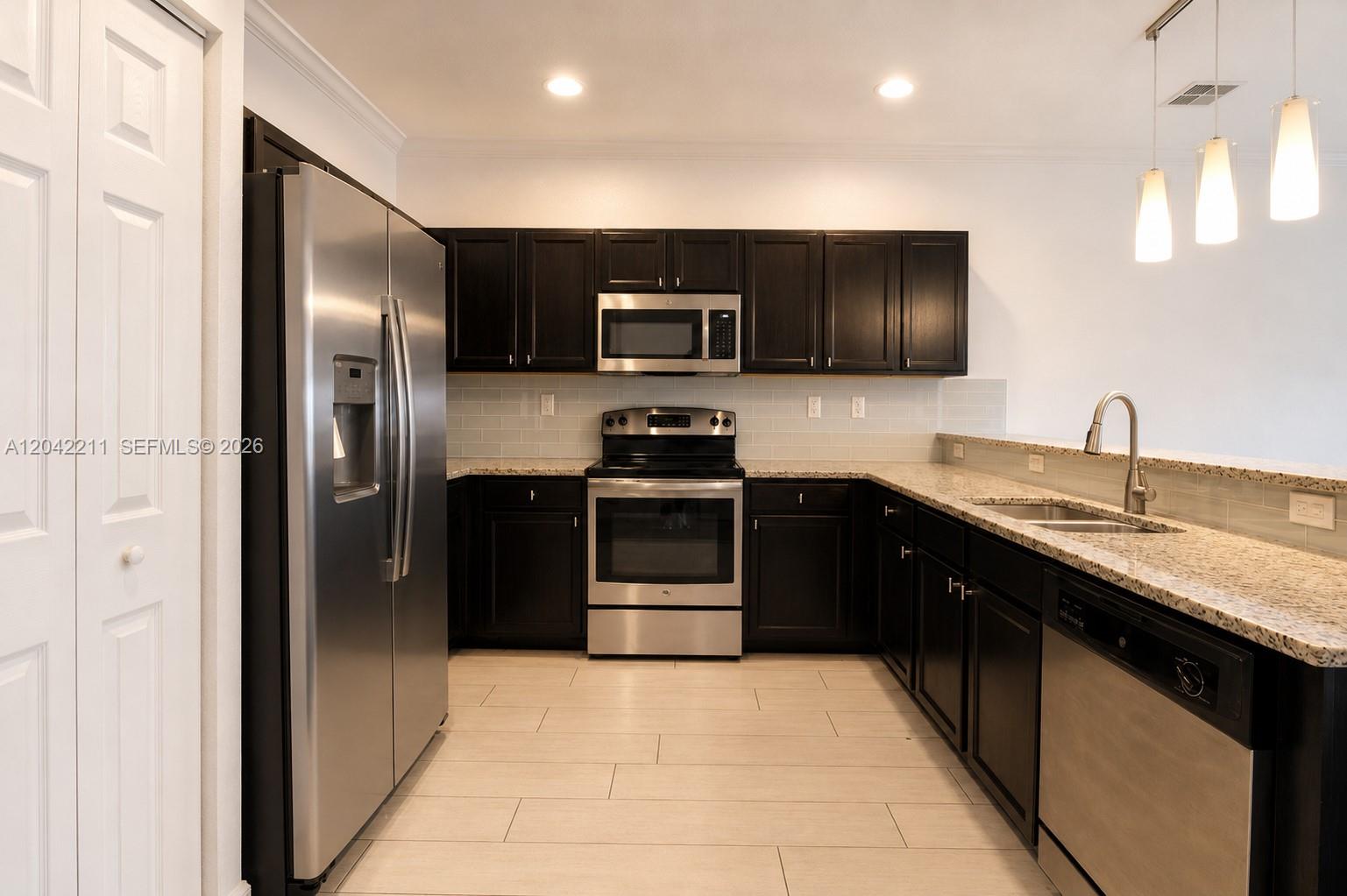 8954 West 35th Way Hialeah, FL 33018 - Photo 6 of 24 a kitchen with a sink and stainless steel appliances