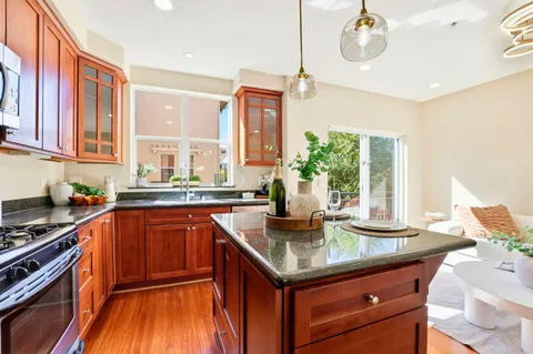 a kitchen with stainless steel appliances granite countertop a sink and a stove