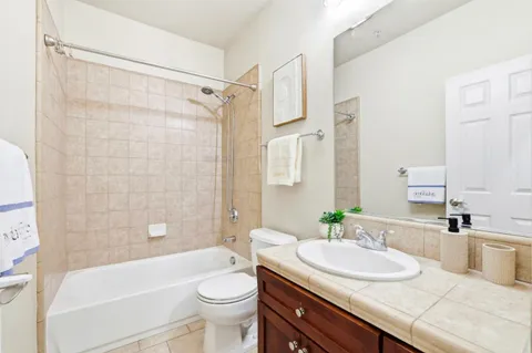 a bathroom with a sink a toilet a mirror a bathtub and shower