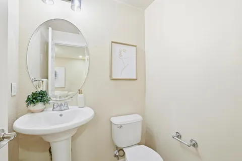 a bathroom with a sink mirror and toilet